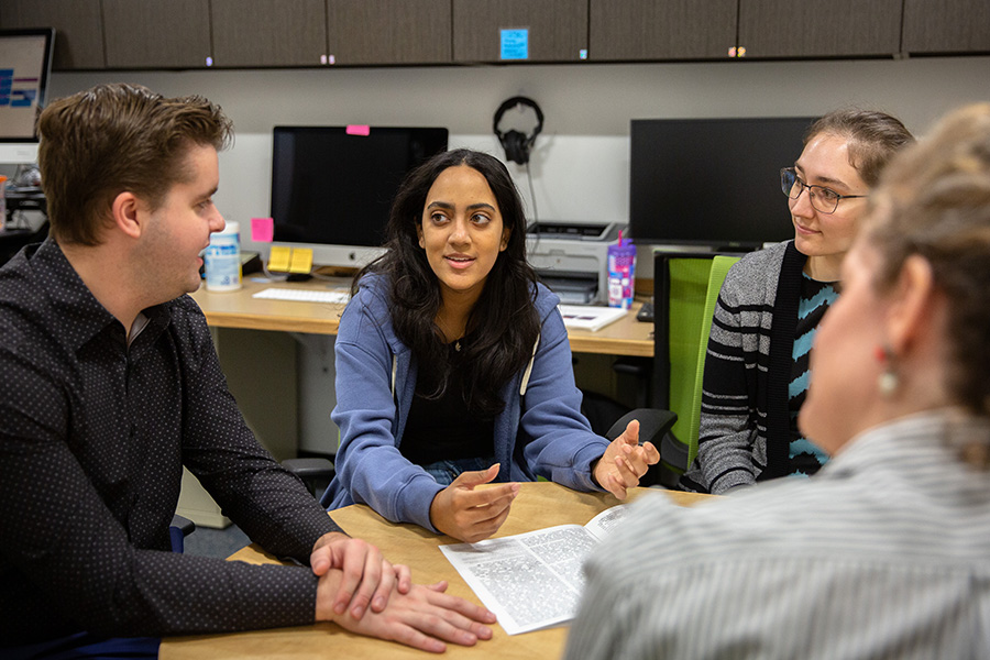 An undergraduate student meets with faculty and graduate student advisors.