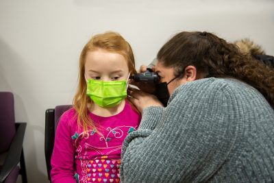 Audiology student performing otoscopy on a pediatric patient. 