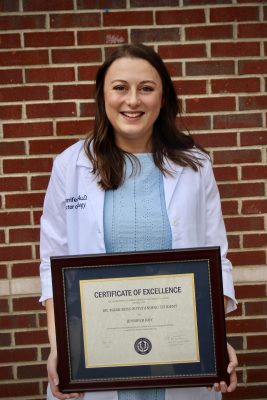 Dr. Mark Ross Outstanding Student - Jennifer Roy, 2023 Audiology Graduate holding her award. 