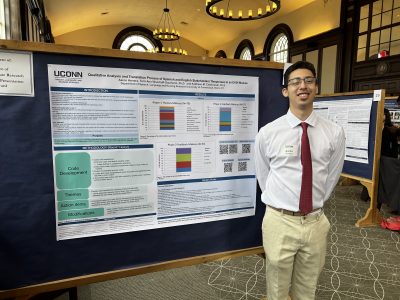 Photo of Aaron in front of poster